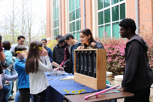 students working with an attendee of the Atlanta Science Festival