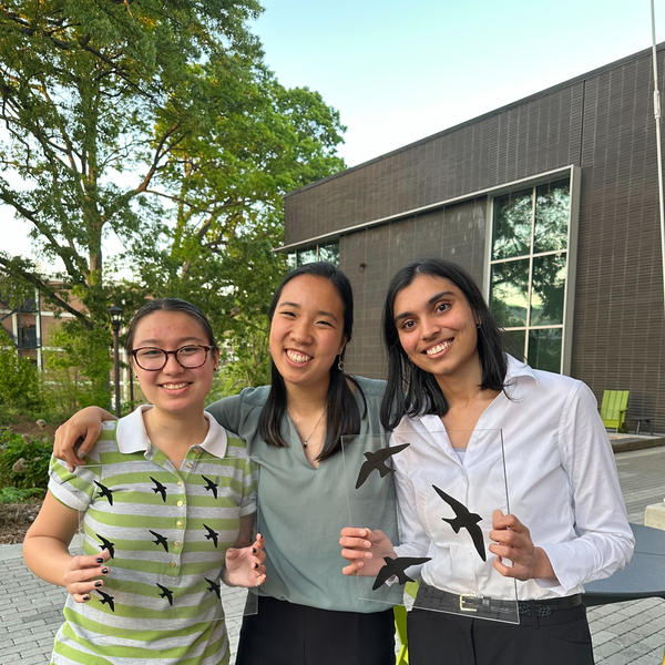 Amanda Janusz, Kaitlyn Tran, and Shivani Potdar hold up their proposed window film graphics that deter bird collisions with windows.