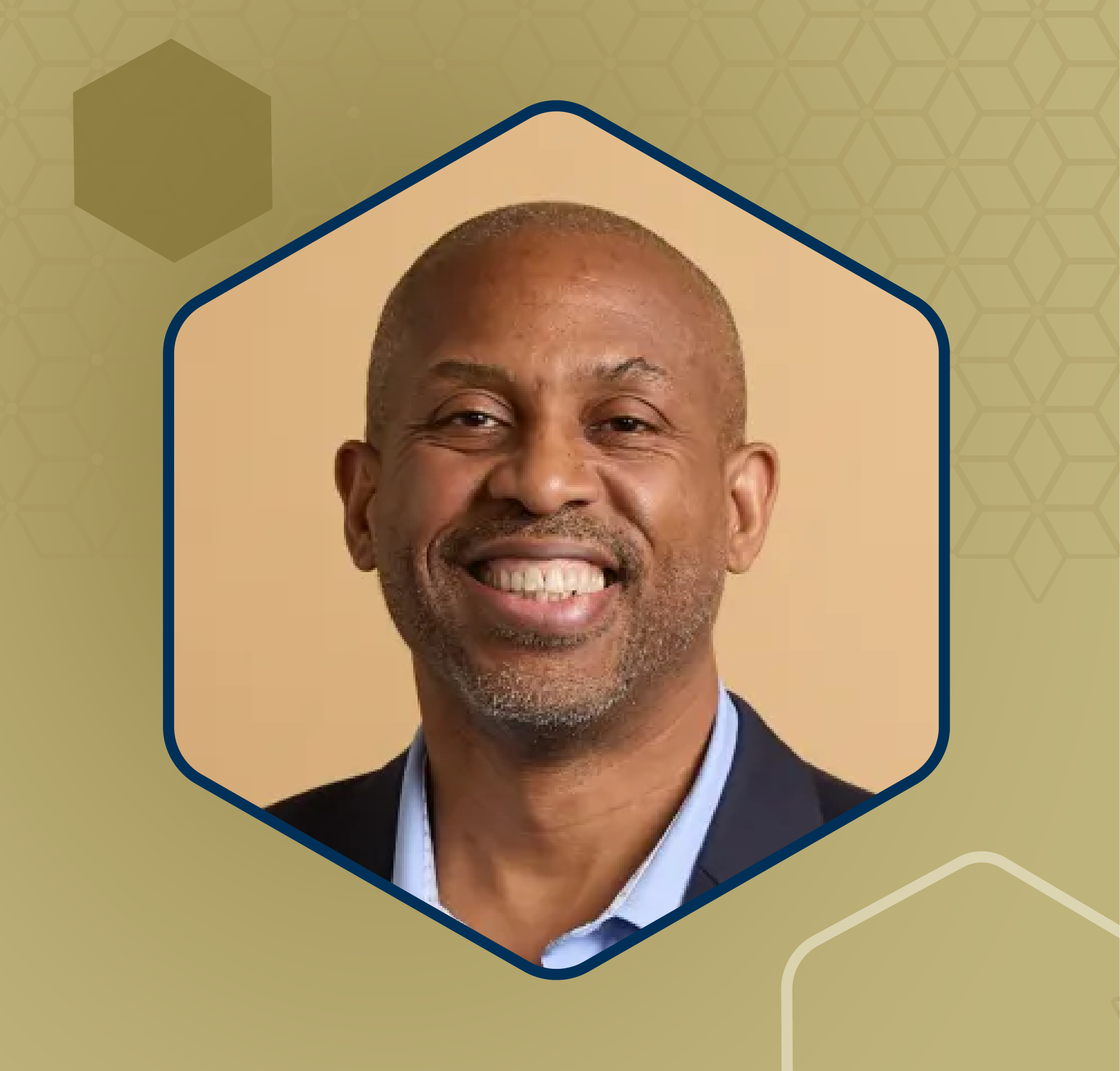 Professional headshot of an individual wearing a dark jacket and collared shirt against a tan background.