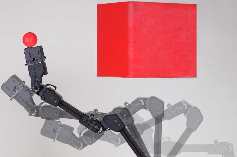 A black robot arm with a small red ball attached to it, and what appears to be a floating red cube off to the side. Chen, Lipson, Nisselson, Qin/Columbia Engineering