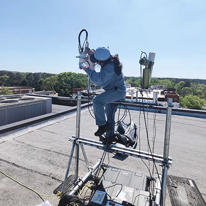 Yakun Zhou, CEE Ph.D. student, installs a Pandora instrument on the roof of Perimeter College-Georgia State University.