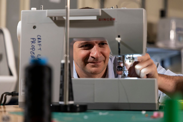 man's face peering through a sewing machine