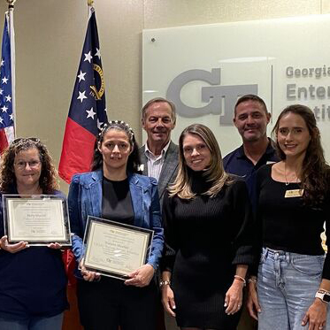 group of people standing in a room next to a flag