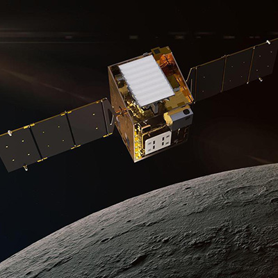 A small satellite with extended solar panels orbiting near the Moon against a dark space background.