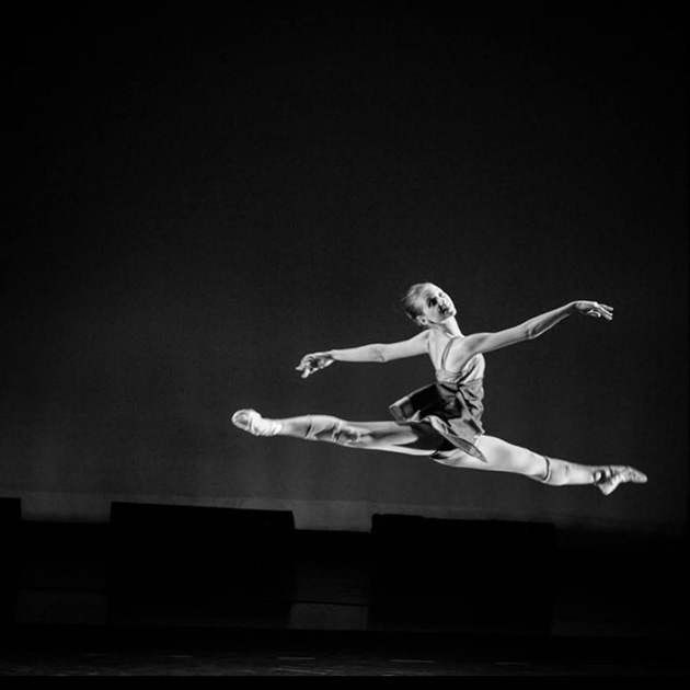 female ballerina making a leap on a dark background