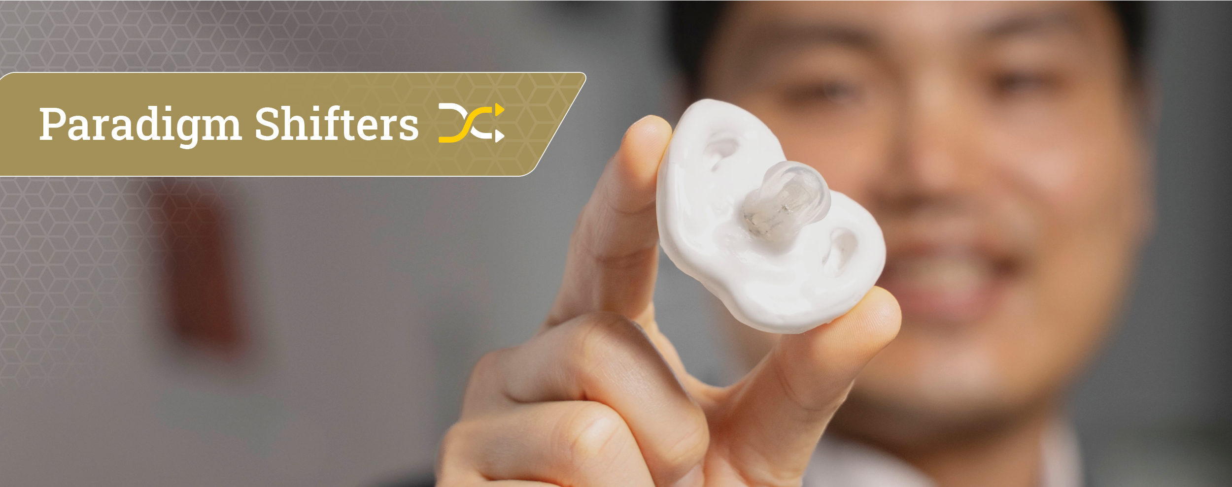 male researcher in background holds a white pacifier