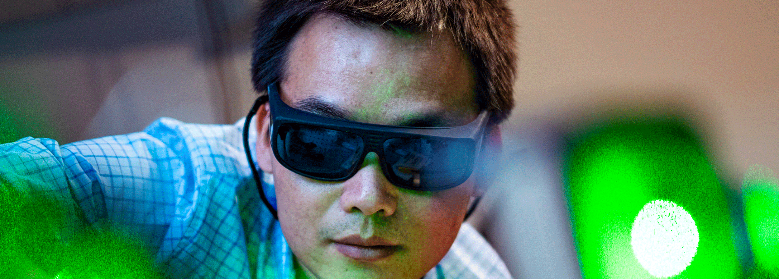 Banner image of a researcher with glasses on 