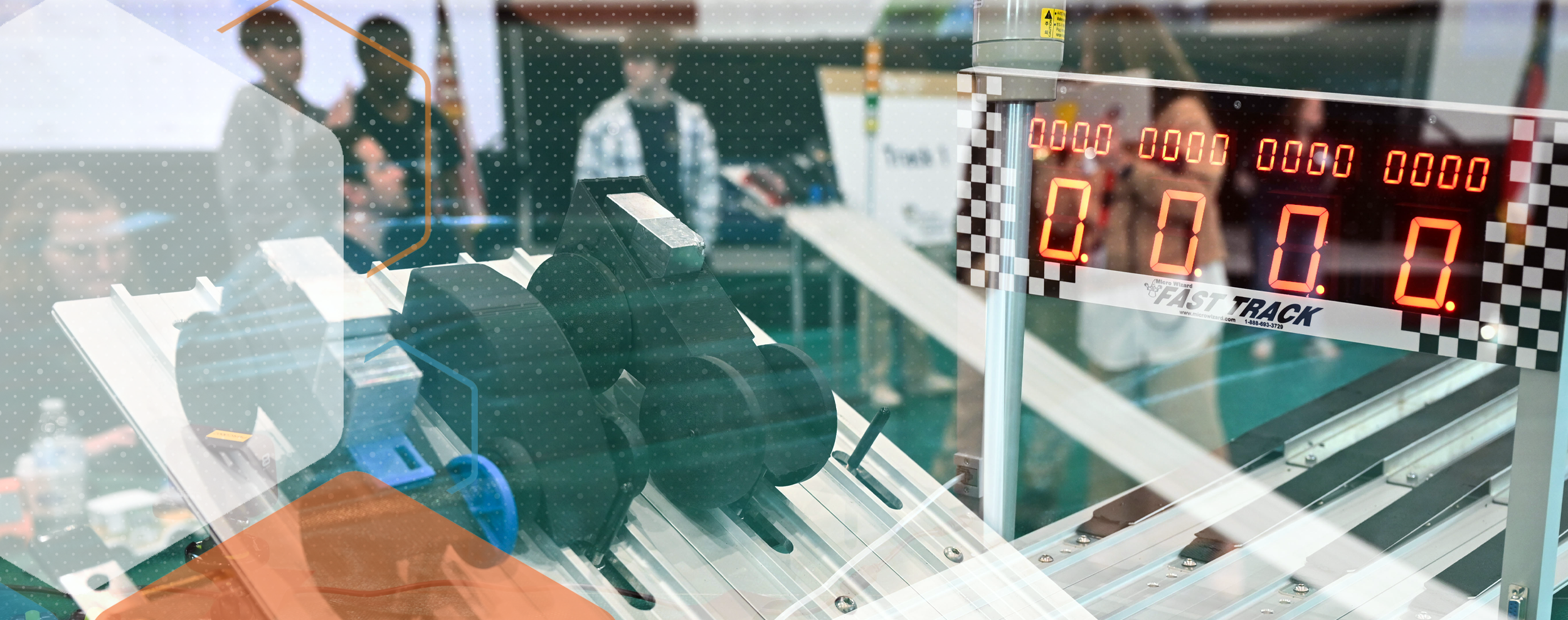 Racetrack setup with small vehicles positioned at the starting line and an electronic timer display showing zeros at a Fast Track competition.