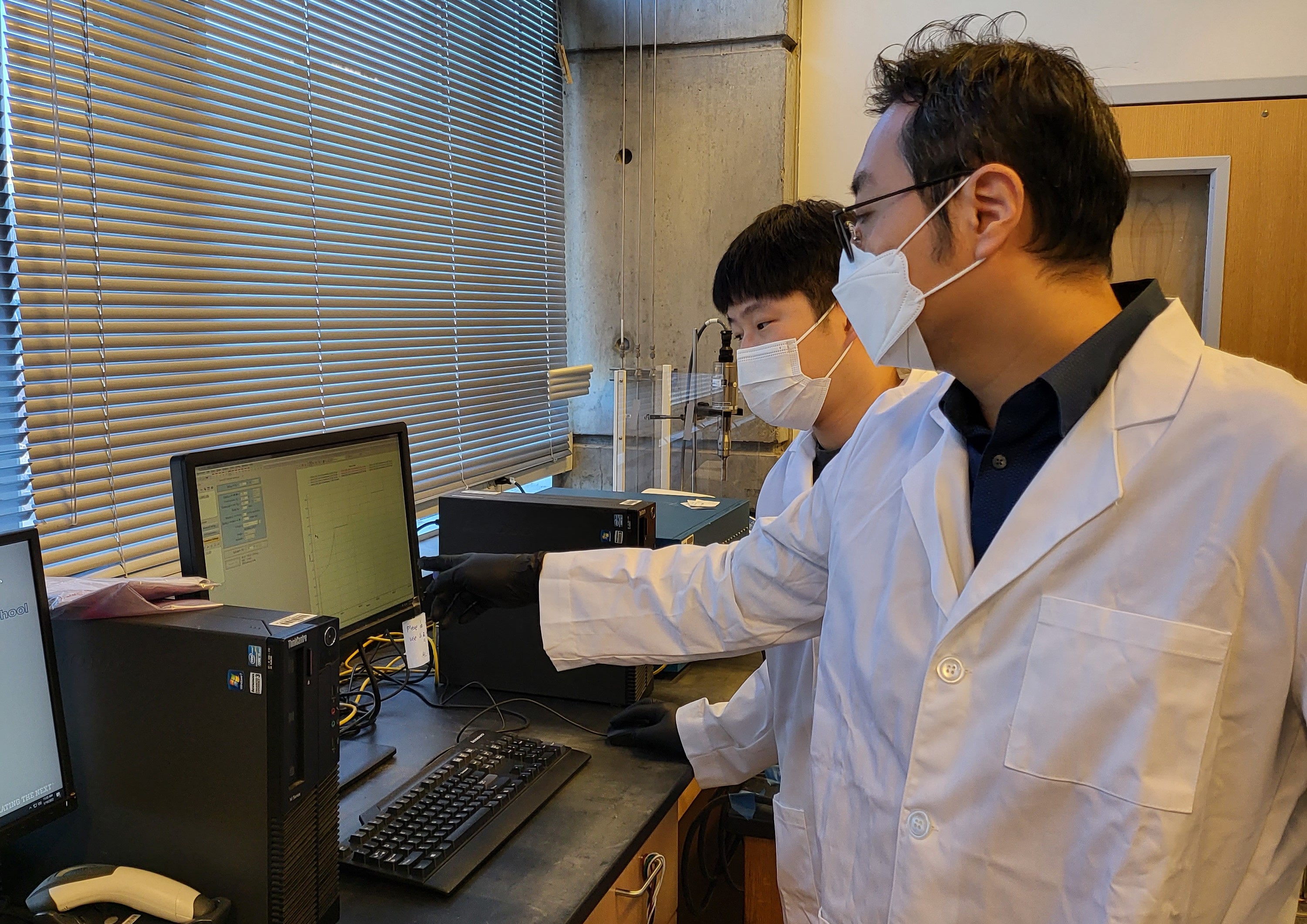 Prof. Seung Woo Lee (right) and Michael J. Lee (left) have charged the rubber-material-based all-solid-state battery using galvanostatic techniques. (Photo credit: Georgia Tech)