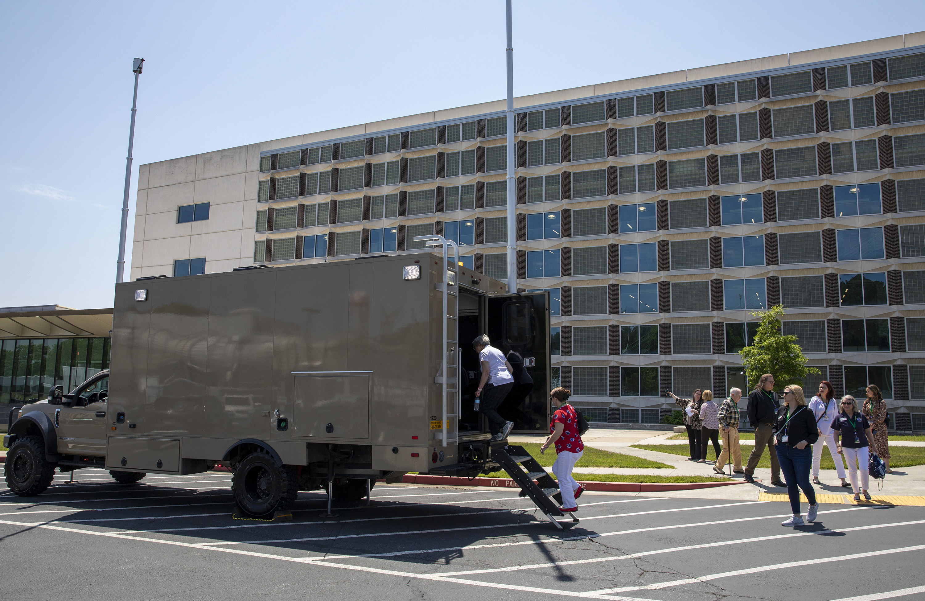 The GTRI Research Electronic Warfare Truck (GREWT), a modified Ford F-550 truck shown here being toured by members of the Honorary Commanders Alumni Association, supports field testing of aircraft defensive systems. (Credit: Sean McNeil, GTRI)
