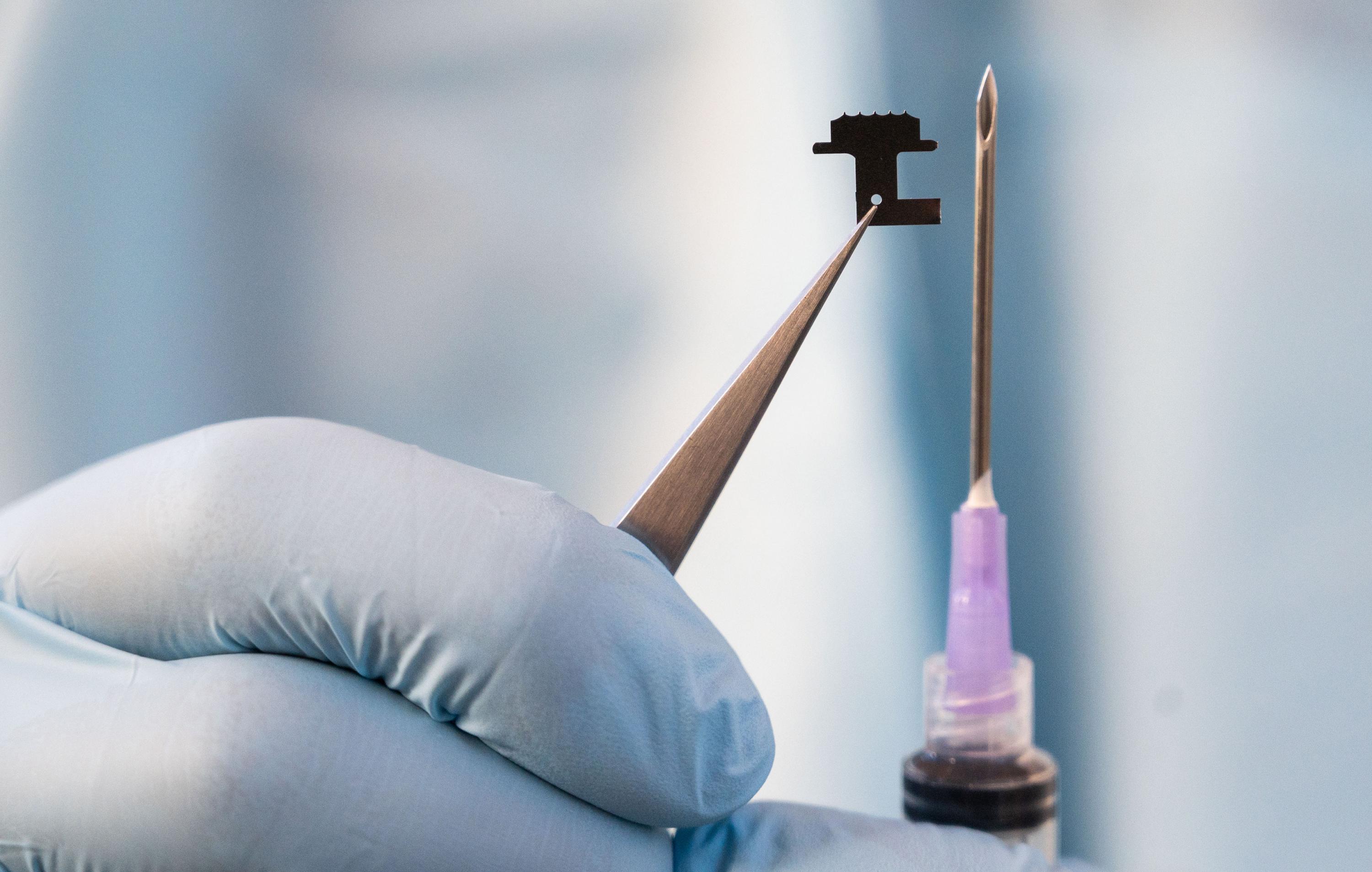 Size comparison of a microneedle patch used to extract interstitial fluid versus a hypodermic needle used to obtain blood samples. (Credit: Allison Carter, Georgia Tech)