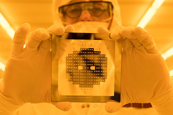 A researcher examining a chip in Georgia Tech's cleanroom, one of the largest of its kind in the U.S.