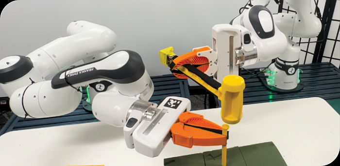These are two Franka Emika Panda robotic arms collaborating on a task.