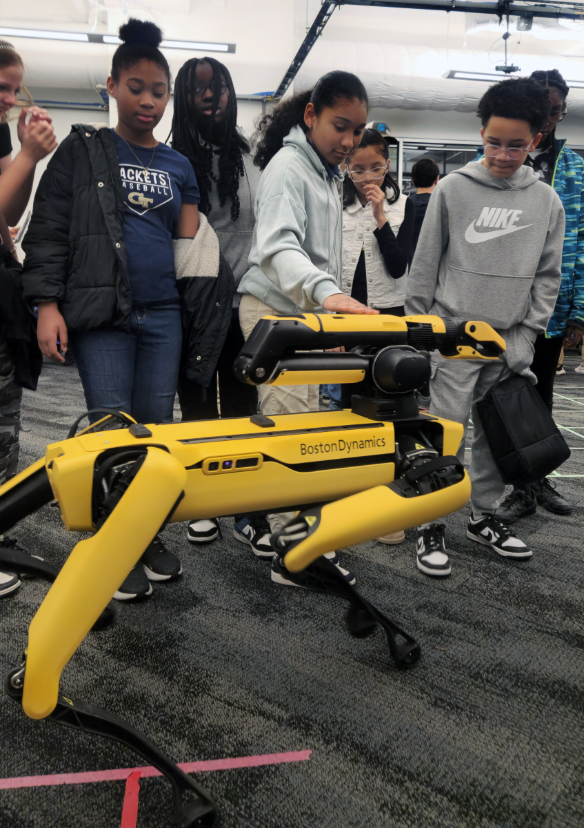 Middle School Students petting a Boston Dynamics Spot Robot at Georgia Tech