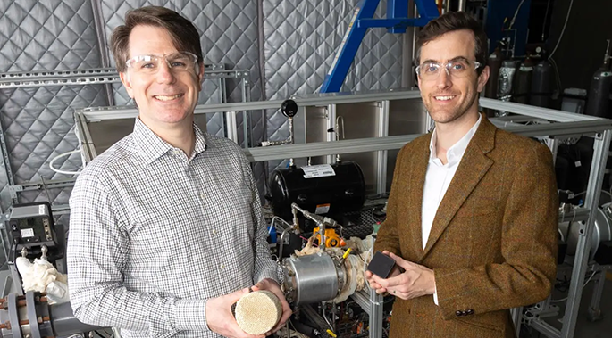 Chris Jones, left, and Ryan Lively hold two kinds of filters for direct air capture systems. The test rig behind them uses the larger filter Jones is holding.