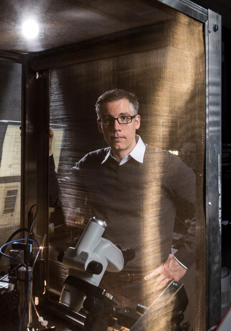 <p>School of Mechanical Engineering associate professor Craig Forest has developed automated patch-­clamping instruments to accelerate the recording of information from neurons. In this photo, an instrument is protected by a Faraday cage. Credit: Georgia Tech / Rob Felt</p>