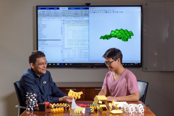 <p>Researchers Glaucio Paulino (left) and Ke Liu with origami structures that can be simulated in new software. (Credit: Rob Felt, Georgia Tech) </p>