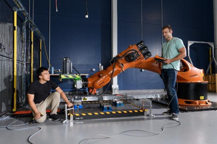 <p>Toni Cvitanic (right) with Kuka industrial robot with Vinh Nguyen</p>