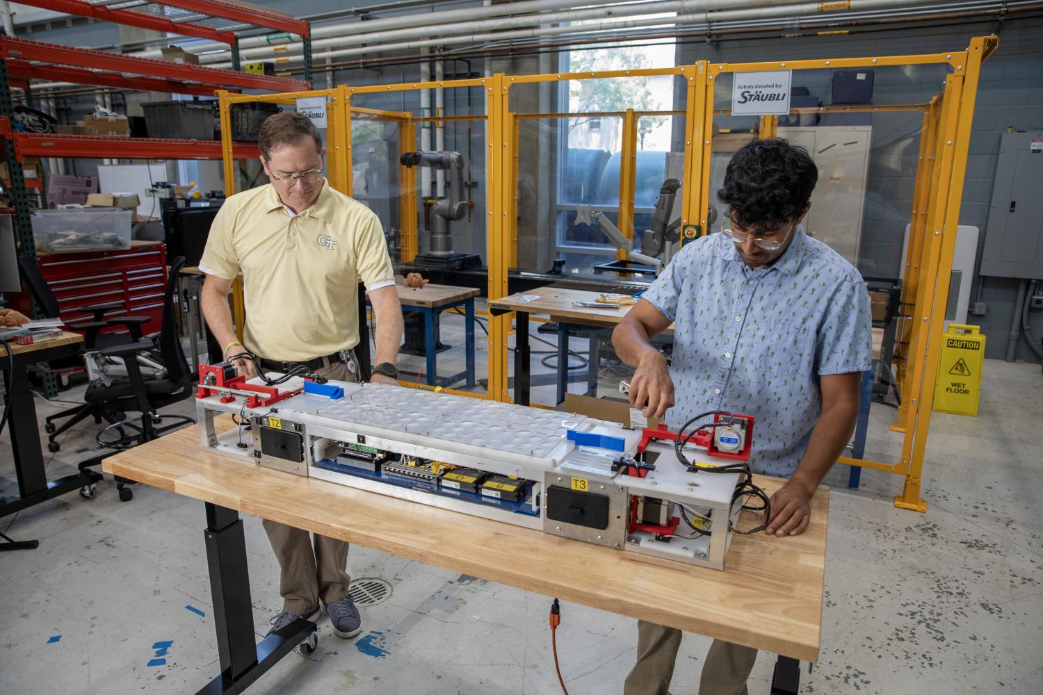 A photo of two GTRI researchers working on the BHIG-MESS prototype. 