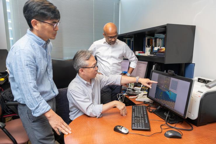 <p>Seung Soon Jang, an associate professor, Faisal Alamgir, an associate professor, and Ji Il Choi, a postdoctoral researcher, all in Georgia Tech’s School of Materials Science and Engineering, study a graphical representation of a new platinum-graphene catalyst. (Credit: Allison Carter)</p>