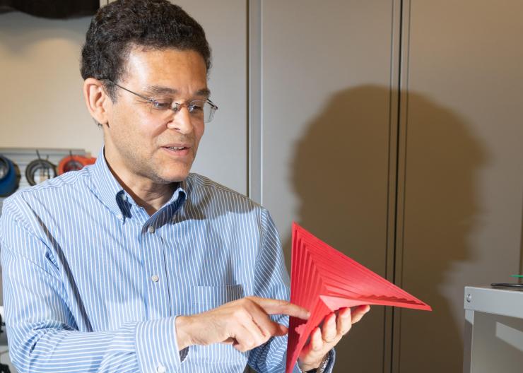<p>Glaucio Paulino, a professor and the Raymond Allen Jones Chair of Engineering in the Georgia Tech School of Civil and Environmental Engineering, holds a "hypar" origami. (Credit: Allison Carter)</p>
