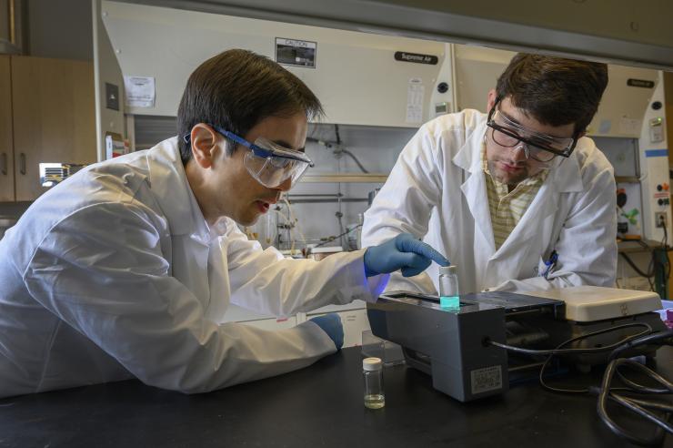 <p>Zhiqun Lin, a professor in the Georgia Tech School of Materials Science and Engineering, and Gill Biesold-Mcgee, a graduate student at Georgia Tech, examine samples of the new perovskite. (Credit: Christpher Moore)</p>