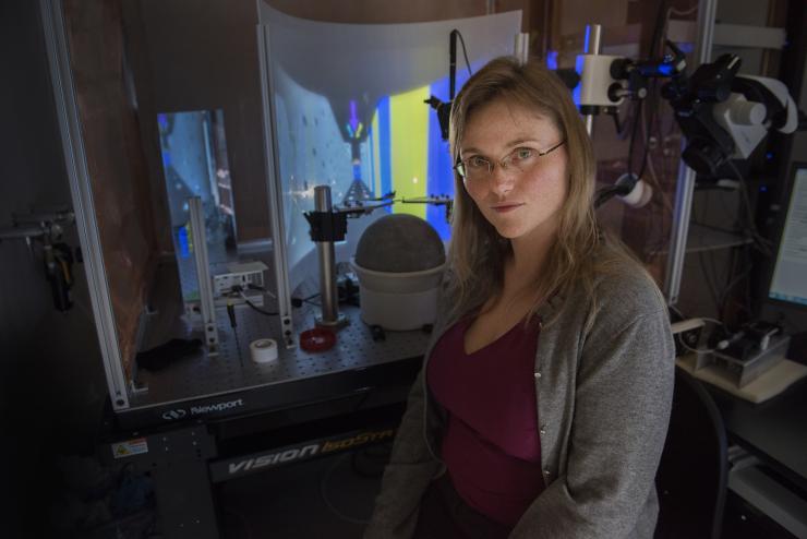<p>Annabelle Singer, assistant professor in the Wallace H. Coulter Department of Biomedical Engineering, studies how the hippocampus’ neurons fire as the brain creates orientation in a video maze seen in the background. Photo: Georgia Tech / Christopher Moore</p>