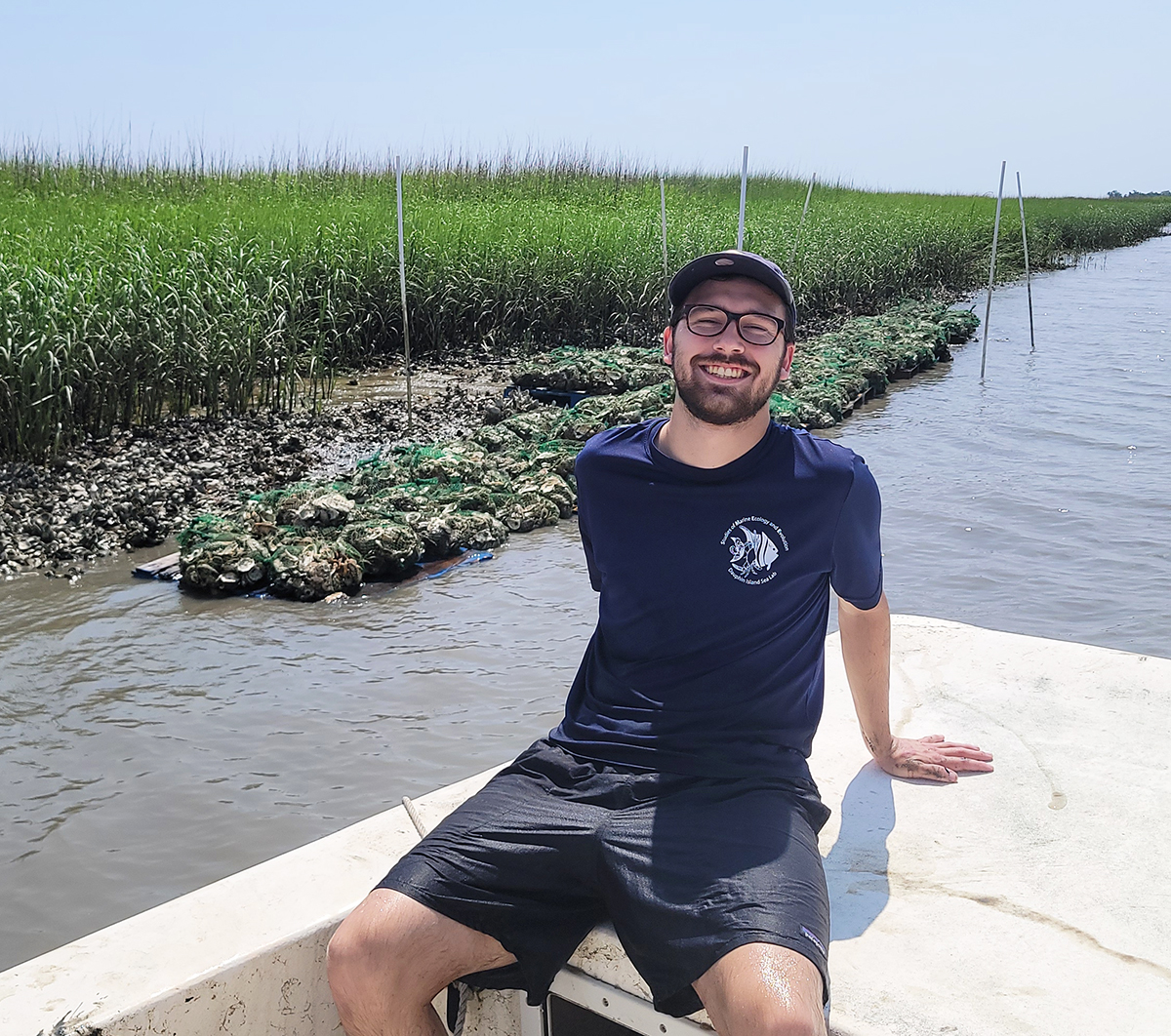 Tanner Lee (Georgia Tech, BS Biology '23) helped construct the oyster reef he observes from a boat as part of an undergraduate research project.