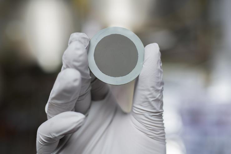 A new boost to fuel cell technology: A nanoparticle coating on this disc turbocharges the processing of oxygen on the cathode end of solid oxide fuel cells, increasing eightfold current best performance. Credit: Georgia Tech / Christopher Moore
