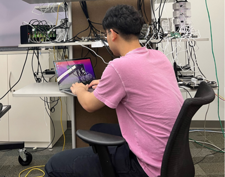 Georgia Tech PhD student Difei Cao showing a lab prototype of “MicroEdge,” a low-cost edge micro-data center using Raspberry Pis and DNN accelerators such as Coral TPUs. Credit: Ying Chen, Georgia Tech)