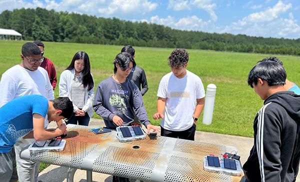 <p>Students from the Energy Unplugged Savannah camp conduct experiments with solar panels.</p>