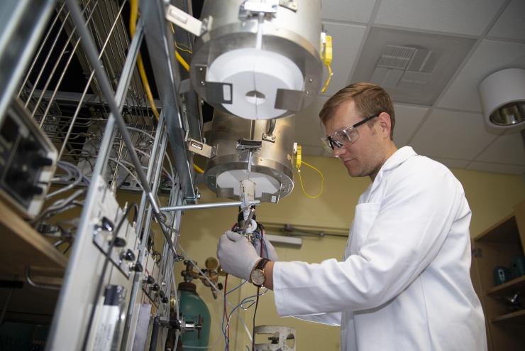 <p>Graduate research assistant Ben deGlee hooks up electrodes to a testing unit used to test the new fuel cell in Meilin Liu's lab at Georgia Tech. Credit: Georgia Tech / Christopher Moore</p>