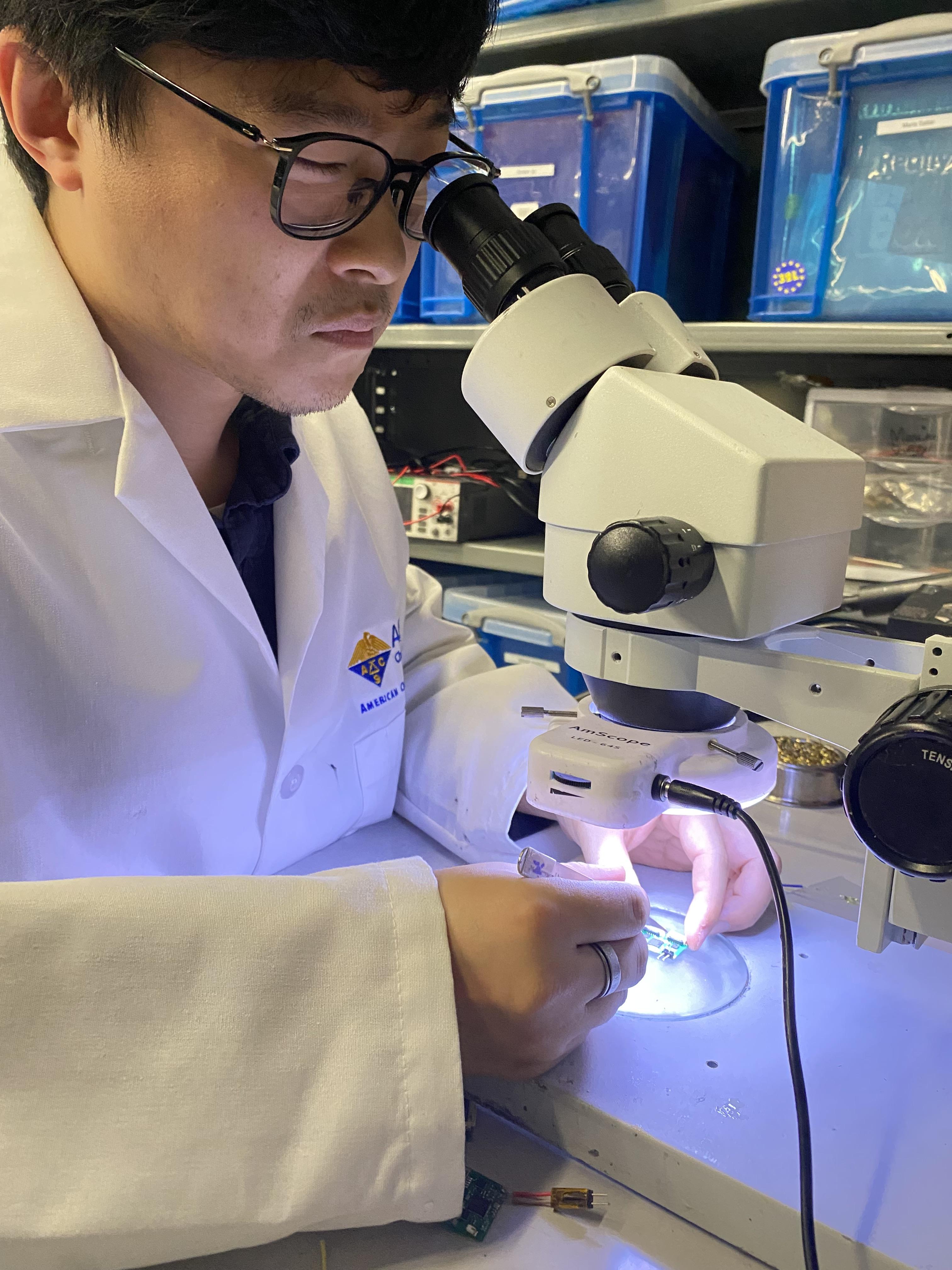 This is a picture of a post-doctoral student in Hong Yeo's lab working on one of the tiny circuits used in the device.