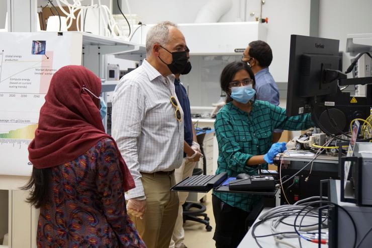 <p>Besides its negative capacitance properties, FEFETs are also an emerging candidate in the embedded memory space. Nujhat Tasneem's current work involves characterizing FEFET's performance as a memory device. Some of her characterization experiments were also shown to President Ángel Cabrera (center). At the right is Tasneem and at the left is Nashrah Afroze.</p>