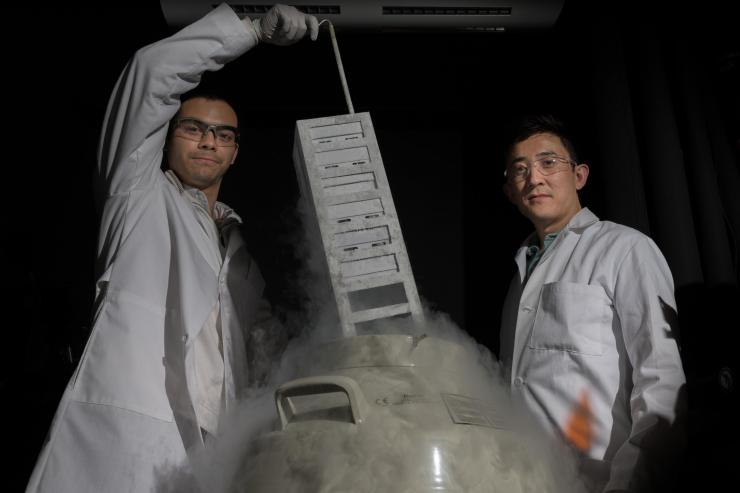 <p>Assistant professor Gabe Kwong (r.) and graduate research assistant Ian Miller (l.) in Kwong's lab at Georgia Tech. T-cells are preserved in the lab in liquid nitrogen. Credit: Georgia Tech / Allison Carter</p>