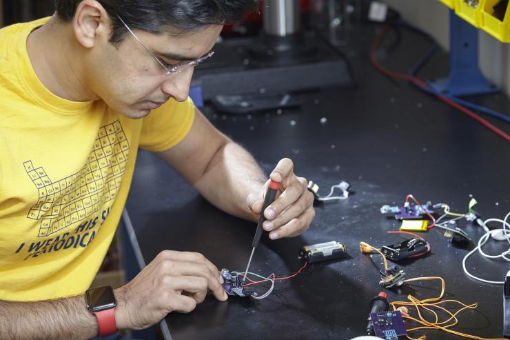 <p>Georgia Tech Assistant Professor M. Saad Bhamla assembles a prototype LoCHAid, an ultra-low-cost hearing aid built with a 3D-printed case and components that cost less than $1. (Credit: Craig Bromley)</p>