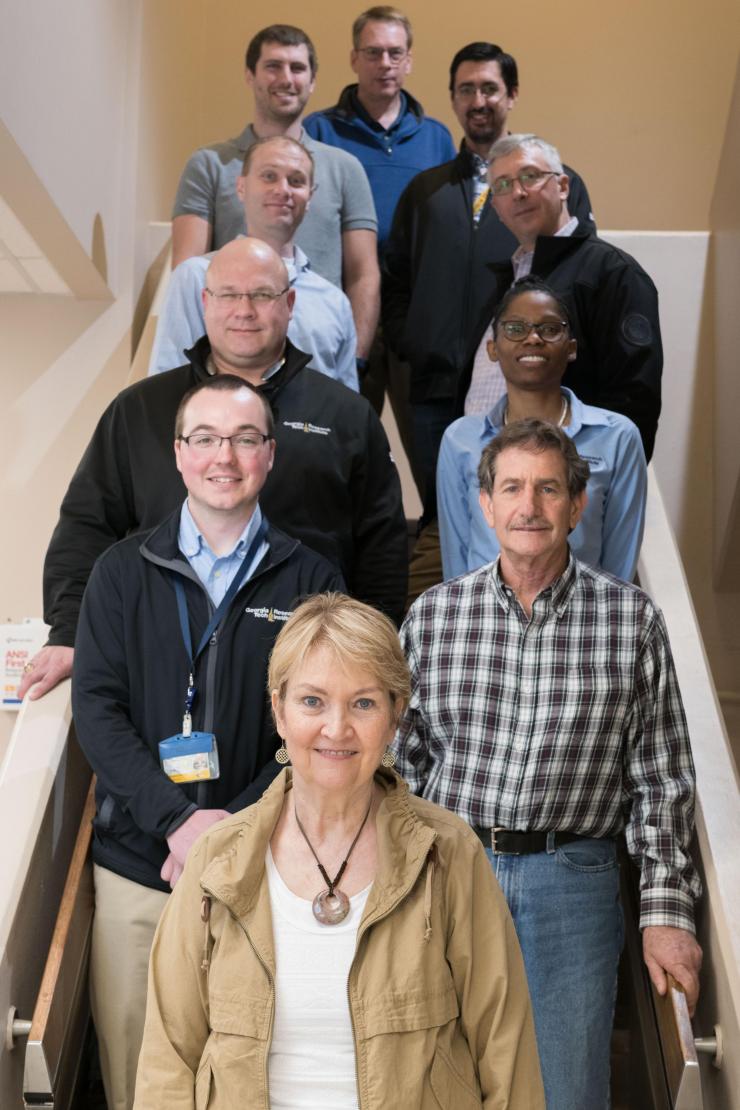 <p>Photo shows a portion of the Atlanta-based GTRI team that is supporting the Air Force Distributed Common Ground System. Shown (foreground to the top, left-to-right) are Molly Gary, Joshua Phillips, Alan Nussbaum, Kyle L. Davis, Jacqueline Fairley, Collin Brown, Lou Tirino, Ryan Simko, Nathan Adams and Jeff Smart. (Photo Credit: Allison Carter, Georgia Tech)</p>