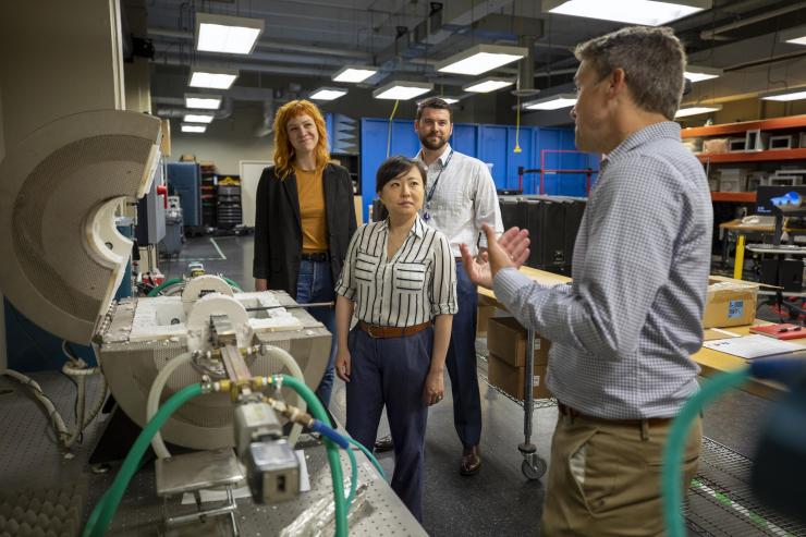 <p>David Reid demonstrates the function of the high=temperature cavity waveguide system for measuring the complex permittivity of different radome materials. (L to R):  Aimee Williams, Ellen Yi Chen Mazumdar, Kenneth Allen, and David Reid. (Photo credit: Sam McNeil, GTRI)</p>