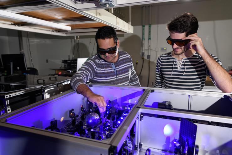 <p>Carlos Silva (l.) in his lab at Georgia Tech with graduate research assistant Félix Thouin examining a setup to process laser light in the visible range for the testing of quantum properties in a halide organic-inorganic perovskite. Georgia Tech / Rob Felt</p>
