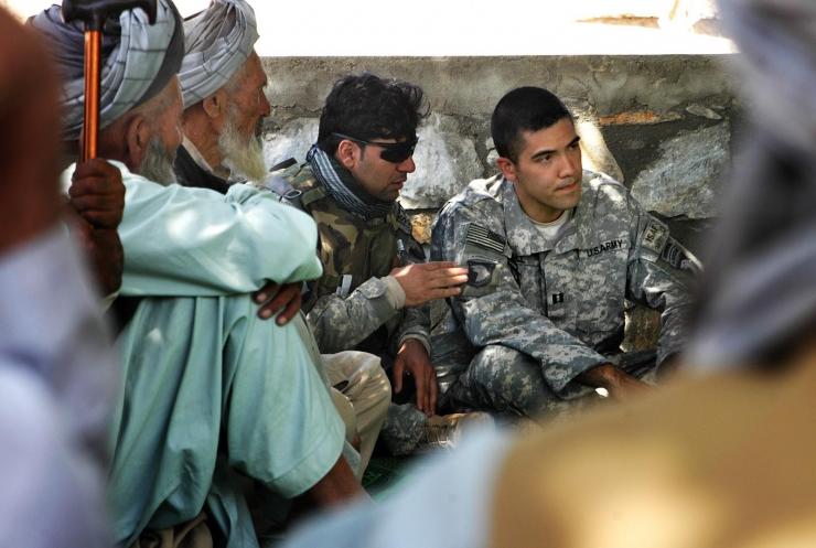 <p><em>Hill pictured with his interpreter during a jirga meeting in Wardak, Afghanistan. Local and national decisions in Afghanistan are typically made by a group of tribal elders known as a jirga (Photo Credit: Roger Hill).  </em></p>