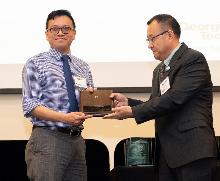 Peter Yunker accepts his award from Mehanical Engineering Professor Zhuomin Zhang.