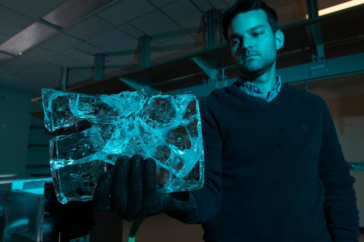 <p>Principal investigator Alex Robel holds up ice that has been reduced by contact with water, revealing patterns of ice destruction. Credit: Georgia Tech / Allison Carter</p>