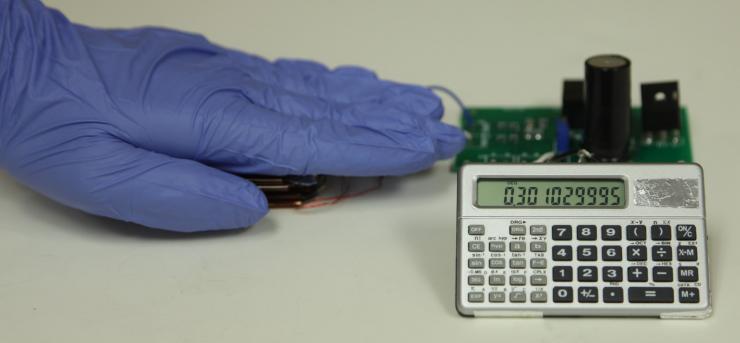 <p>With this triboelectric nanogenerator and two-stage power management and storage system, finger tapping motion generates enough power to operate this scientific calculator. (Credit: Zhong Lin Wang Laboratory)</p>
