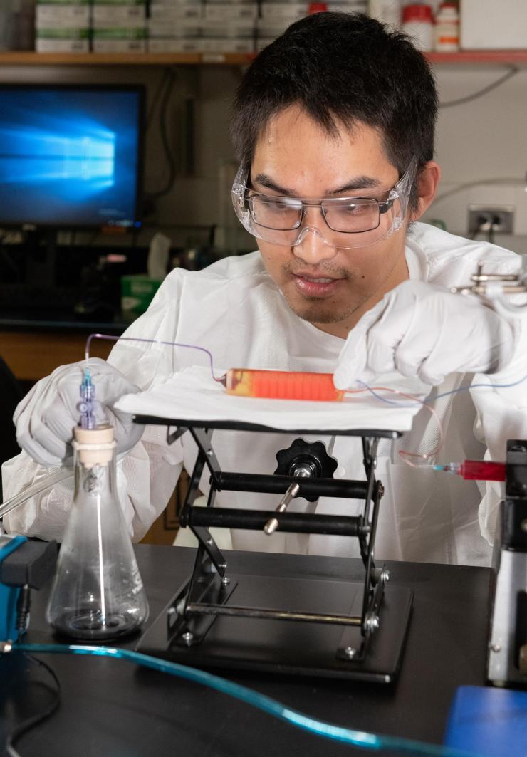 <p>Graduate Student Chia-Heng Chu adjusts a 3D-printed cell trap in the laboratory of Assistant Professor A. Fatih Sarioglu at Georgia Tech. The trap captures white blood cells to isolate tumor cells from a blood sample. (Photo: Allison Carter, Georgia Tech)</p>