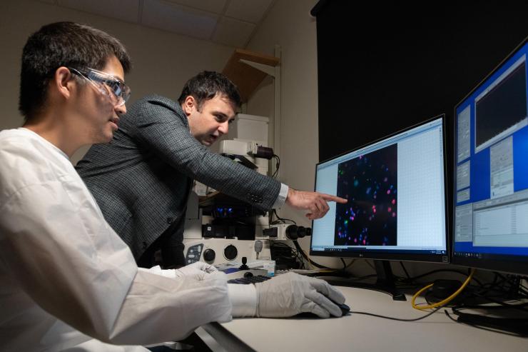 <p>Georgia Tech Graduate Student Chia-Heng Chu and Assistant Professor A. Fatih Sarioglu examine tumor cells captured using their 3D-printed cell trap. The trap captures white blood cells to isolate tumor cells from a blood sample. (Photo: Allison Carter, Georgia Tech)</p>