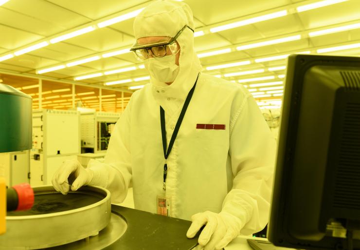 <p>Georgia Tech graduate research assistant Mason Chilmonczyk examines a device after a plasma etch step in a reactive ion etching tool. The work was being done in the Institute of Electronics and Nanotechnology’s Marcus Building clean room. (Credit: Rob Felt, Georgia Tech)</p>