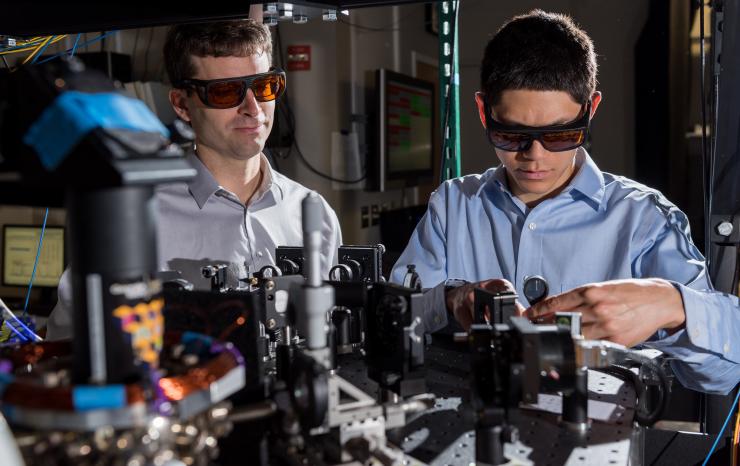 <p>Georgia Tech Research Institute (GTRI) scientists work in an optical lab developing improved ion traps that could be used in quantum computing. Shown are (l-r) research scientists Jason Amini and Nicholas Guise. (Credit: Rob Felt) </p>
