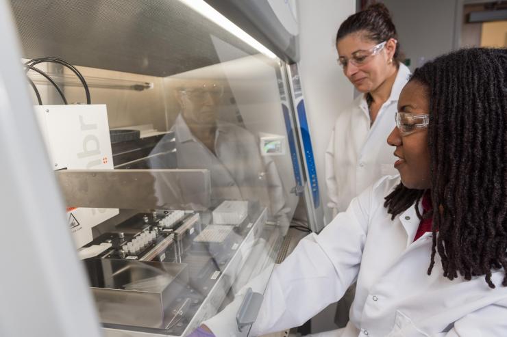<p>Research Scientist Sommer Durham and Research Technician Naima Djeddar set up and initiate process steps for automated cell culture on the AMBR 15 micro-bioreactor in the Engineered Biosciences Building at Georgia Tech. (Credit: Rob Felt, Georgia Tech)</p>
