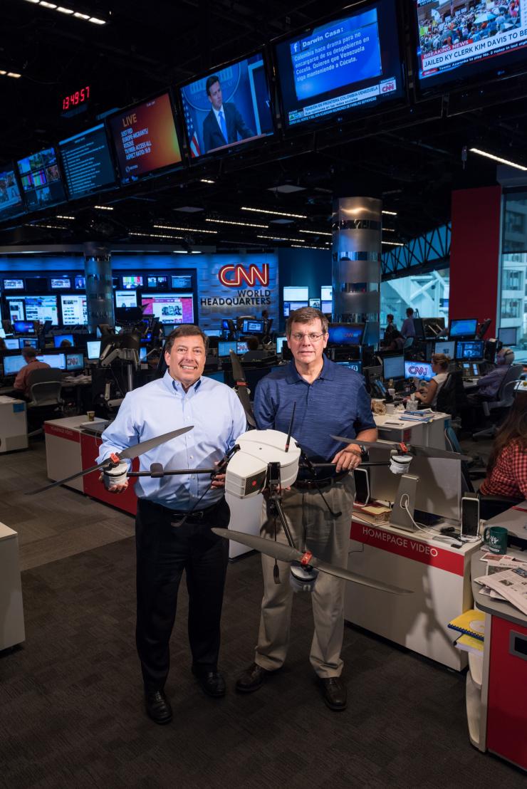 <p>The Georgia Tech Research Institute (GTRI) and CNN have been working together to study the issues affecting the use of unmanned aerial vehicles for newsgathering. Shown in CNN’s World Headquarters are (left) Greg Agvent, senior director of news operations for CNN, and Cliff Eckert, a GTRI senior research associate who’s working on the project. They are shown with an AirRobot AR 180, one of the devices that may be suitable for newsgathering. (Credit: Rob Felt, Georgia Tech)</p>