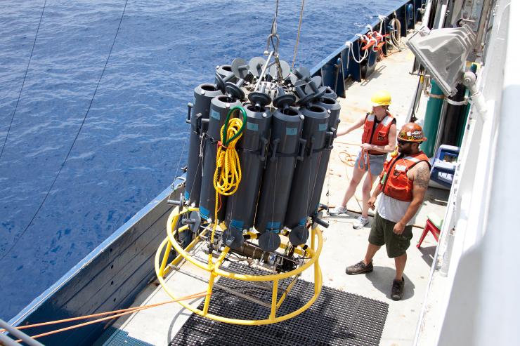 <p>Researchers Liz Robertson from the University of Southern Denmark and Josh Manger from the University of California, San Diego, ready a sample collector. The carrousel of tubes dropped down 1,000 feet to an oxygen minimum zone off Mexico's Pacific coast. Credit: Dr. Heather Olins </p>